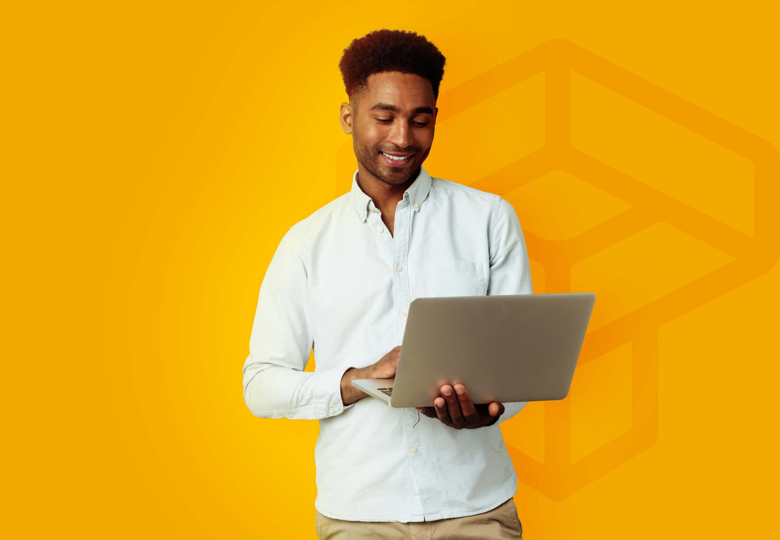 Young smiling african man standing and using laptop computer isolated over gray background